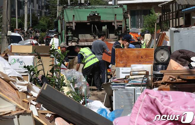 충남 공주시 옥룡동 일대 폭우 침수현장에서 주민들과 자원봉사자들이 물에 젖은 가구 등을 옮기고 있다. 2023.7.17/뉴스1 ⓒ News1 임세영 기자