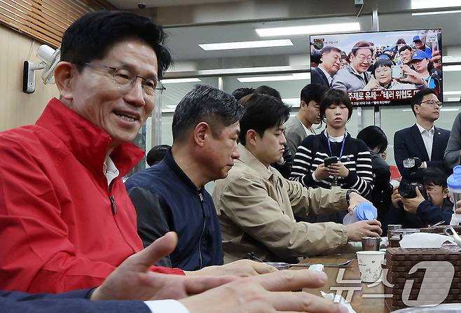 제21대 대통령 선거 공식 선거운동이 시작된 12일 새벽 서울 송파구 양재대로 가락시장에서 김문수 국민의힘 대선 후보가 상인들과 아침식사를 준비하는 가운데 식당에 진열된 텔레비전으로 이재명 더불어민주당 대선 후보 뉴스가 송출되고 있다. 2025.5.12/뉴스1 ⓒ News1 이동해 기자