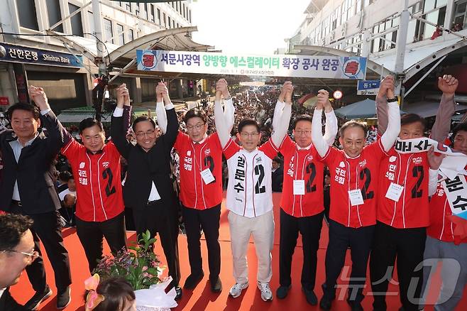 김문수 국민의힘 대선 후보가 12일 대구 중구 서문시장에서 국민의힘 의원들을 비롯한 관계자들과 함께 손을 잡고 시민들에게 지지를 호소하고 있다. (공동취재) 2025.5.12/뉴스1 ⓒ News1 김민지 기자