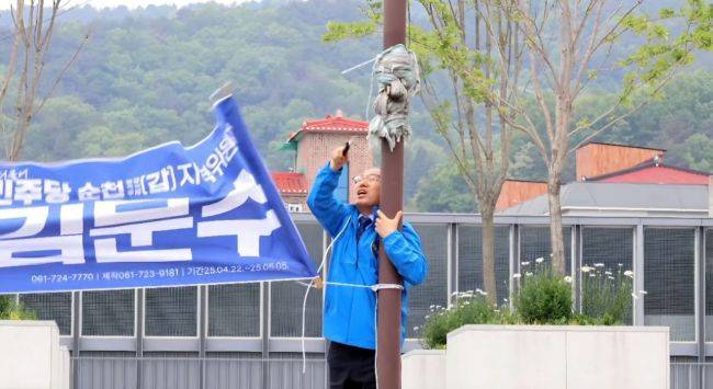 지난 11일 김문수 더불어민주당 의원이 자신의 슬로건이 적힌 현수막을 자진 철거하고 있다. 김문수 의원 페이스북 발췌