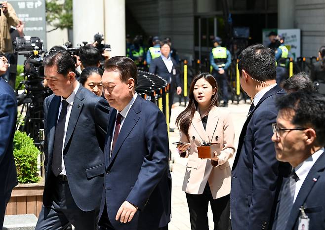 윤석열 전 대통령이 12일 서울 서초구 중앙지방법원에서 열린 내란 우두머리 혐의, 직권남용 권리행사방해 혐의 사건 3차 공판에서 오전 재판 종료 후 식사를 위해 나서다 취재진의 질문에 묵묵부답으로 일관하고 있다. /뉴스1