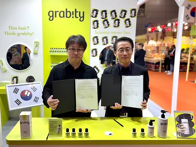 (왼쪽부터) 이해신 (주)폴리페놀팩토리 대표, 김재겸 롯데홈쇼핑 대표가 지난 11일 프랑스 파리 포르트 드 베르사유 전시장에서 기능성 탈모샴푸 '그래비티' 해외수출 독점 계약을 체결하고 기념사진을 촬영하고 있다.