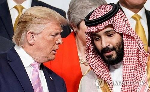 도널드 트럼프(왼쪽) 미국 대통령과 무함마드 빈살만 사우디아라비아 왕세자가 지난 2019년 6월 일본 오사카에서 열린 G20 정상회의에서 회담을 갖고 기념촬영을 하기 전에 귀엣말을 나누고 있다.AFP 연합뉴스