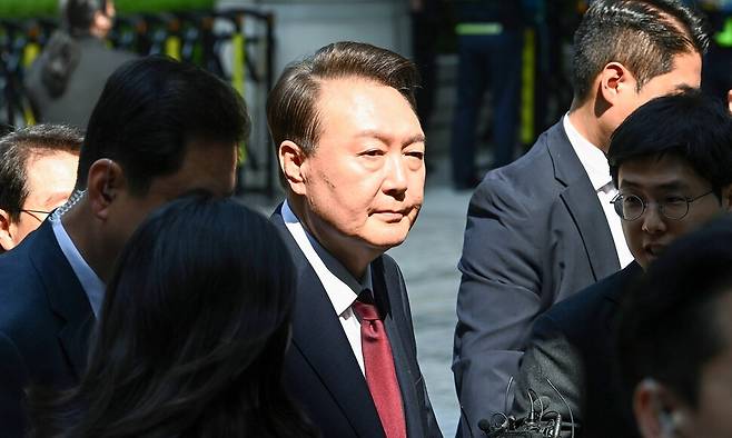 윤석열 전 대통령이 12일 서울 서초구 중앙지방법원에서 열린 내란 우두머리 혐의, 직권남용 권리행사방해 혐의 사건 3차 공판에 출석, 취재진의 질문을 받으며 이동하고 있다. 사진공동취재단