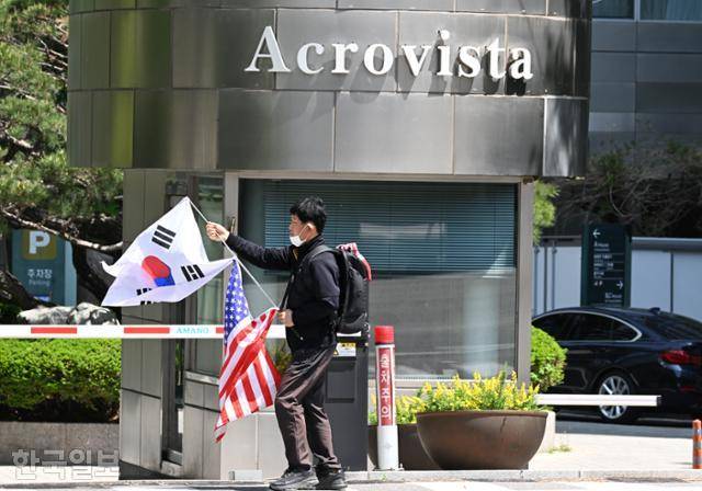 지난달 30일 윤석열 전 대통령 부부 사저가 있는 서울 서초구 아크로비스타 앞에 한 남성이 태극기와 성조기를 든 채 지나가고 있다. 이날 검찰이 윤 전 대통령 사저를 압수수색하자 윤 전 대통령 지지자들은 사저 앞 항의 시위를 벌였다. 왕태석 선임기자