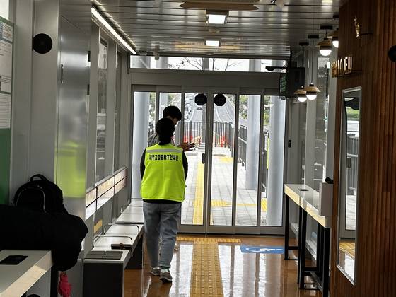 11일 낮 12시 제주시 명신마을 BRT 정류장에서 양문형버스를 기다리는 시민과 교통안내 도우미. 최충일 기자