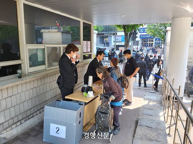 서울중앙지법 관계자들이 12일 오전 서울 서초구 서울중앙지법 동문 출입구에서 출입자들의 소지품을 검사하고 있다. 김태욱 기자