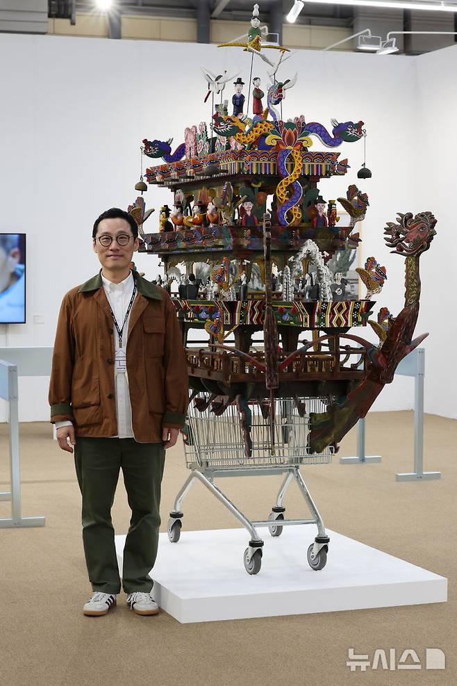 [부산=뉴시스] 박진희 기자 = 고원석 라인문화재단 디렉터가 9일 부산 해운대구 벡스코 전시장에서 열리고 있는  '아트부산 2025' 김상돈 작가의 작품 '카트'을 살펴보고 있다. 2025.05.09. pak7130@newsis.com