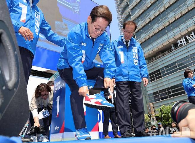 [서울=뉴시스] 조성우 기자 = 이재명 더불어민주당 대선후보가 제21대 대통령선거 공식 선거운동이 시작된 12일 오전 서울 청계광장에서 열린 중앙선거대책위원회 출정식에서 운동화를 신고 있다. (공동취재) 2025.05.12. photo@newsis.com