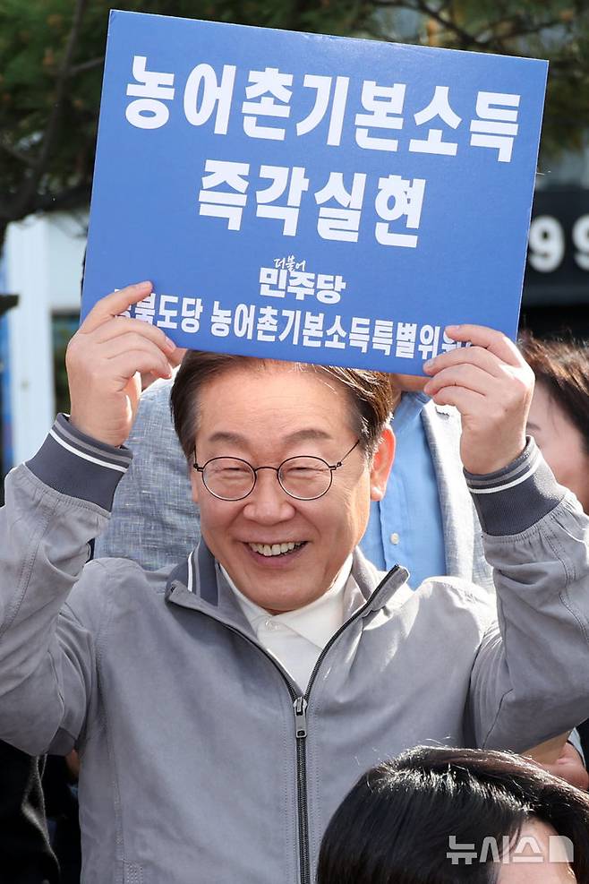 민심을 청취하는 '경청 투어'에 나선 이재명 더불어민주당 대선후보가 농어촌기본소득 즉각실현이라고 적힌 손팻말을 들어 보이고 있다. 2025.05.03. xconfind@newsis.com