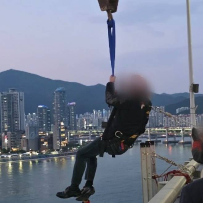 11일 부산 광안대교에서 고공 농성을 벌인 형제복지원 피해 생존자 최승우씨가 8시간 만에 구조되고 있다. 부산경찰청 제공