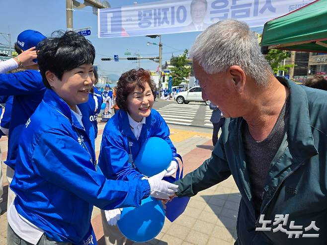 왼쪽부터 서선란·이영란 순천시의원이 아랫장 출정식에서 밝은 표정으로 시민과 악수하고 있다. 고영호 기자