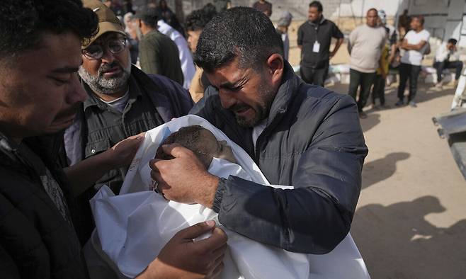 11일(현지시간) 팔레스타인 가자 지구에서 이스라엘군의 공습으로 두살배기 어린이가 사망한 가운데 그 삼촌이 조카의 시신을 부둥켜 안은 채 울먹이고 있다.&nbsp;AP연합뉴스