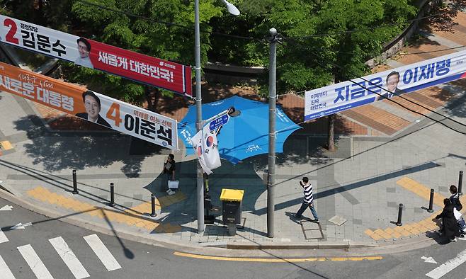 제21대 대통령선거 공식 선거운동 첫날인 12일 서울 성북구 성북경찰서 인근에 더불어민주당 이재명 후보, 국민의힘 김문수 후보, 개혁신당 이준석 후보의 현수막이 걸려 있다. 연합뉴스