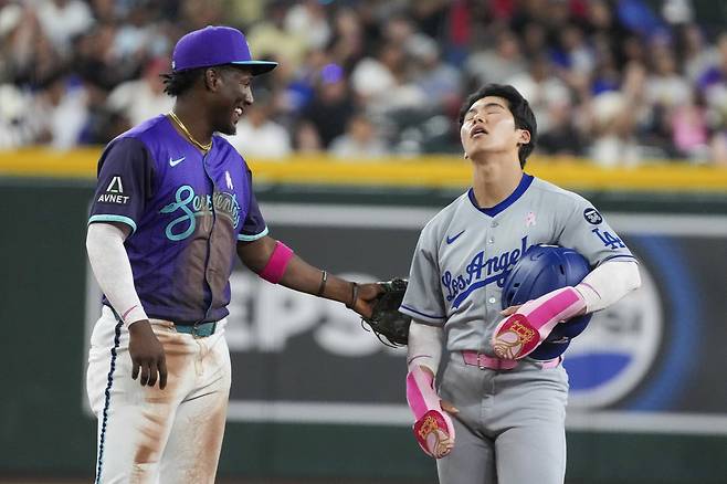 애리조나 유격수 페랄도 헤도모(왼쪽)가 12일 LA 다저스와의 경기에서 비디오 판독 끝에 아웃된 다저스 김혜성을 위로하고 있다. 피닉스 | AP연합뉴스