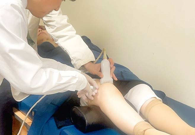 가톨릭중앙의료원 첨단세포치료사업단의 주지현 교수가 가톨릭대 서울성모병원에서 줄기세포를 활용한 3D 연골 세포 주사제를 환자에 투여하고 있다. [가톨릭중앙의료원 제공]