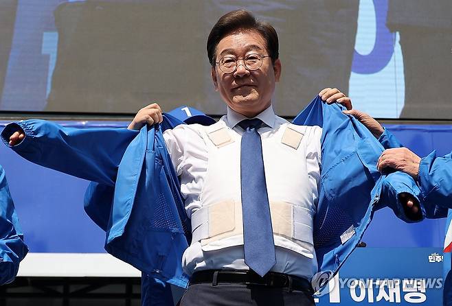 방탄복 입고 공식 선거운동 시작한 이재명 후보 (서울=연합뉴스) 김주성 기자 = 더불어민주당 이재명 대선 후보가 6·3 대통령선거 공식 선거운동 첫날인 12일 서울 광화문 청계광장에서 열린 중앙선대위 출정식 및 첫 유세에서 방탄복 위에 선대위 점퍼를 입고 있다. 2025.5.12 utzza@yna.co.kr