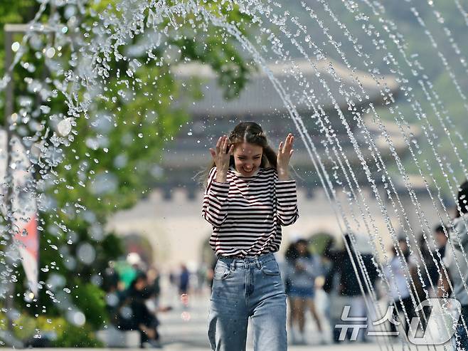 대체로 맑고 포근한 '초여름 날씨'를 보인 12일 오후 서울 광화문광장 분수터널에서 외국인 관광객들이 더위를 식히고 있다. 2025.5.12/뉴스1 ⓒ News1 황기선 기자