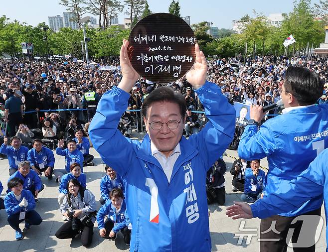 이재명 더불어민주당 대통령 후보가 제21대 대통령 선거 공식 선거운동 첫날인 12일 오후 경기 화성시 동탄 센트럴파크 음악분수중앙광장에서 '세계 1위 반도체 강국 도약!'이라고 쓴 반도체 웨이퍼를 들어 보이고 있다. 2025.5.12/뉴스1 ⓒ News1 안은나 기자