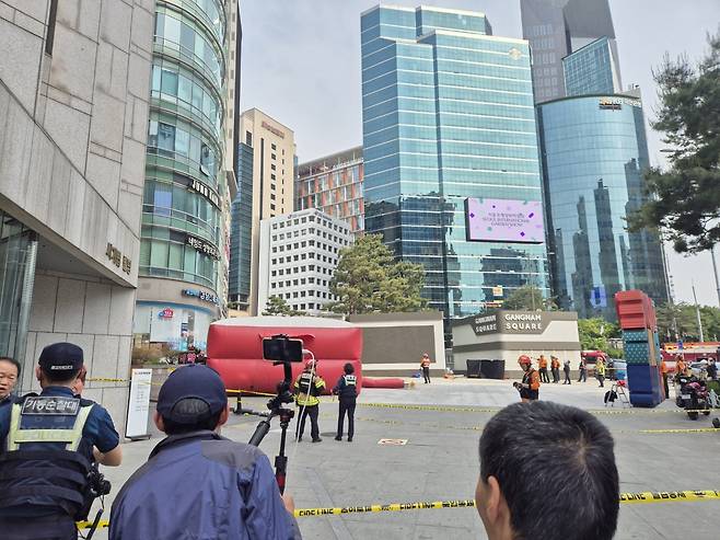 13일 서울 강남역 인근의 한 빌딩 옥상 난간에 한 시민이 올라 소방당국이 에어매트를 설치한 모습 . 2025.5.13/뉴스1 ⓒ News1 남해인 기자
