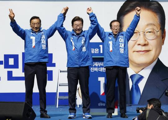 이재명(가운데) 더불어민주당 대선 후보가 6·3 대통령선거 공식 선거운동 첫날인 지난 12일 서울 광화문 청계광장에서 열린 출정식 및 첫 유세에서 두 팔을 들어 올리고 있다. [연합뉴스]