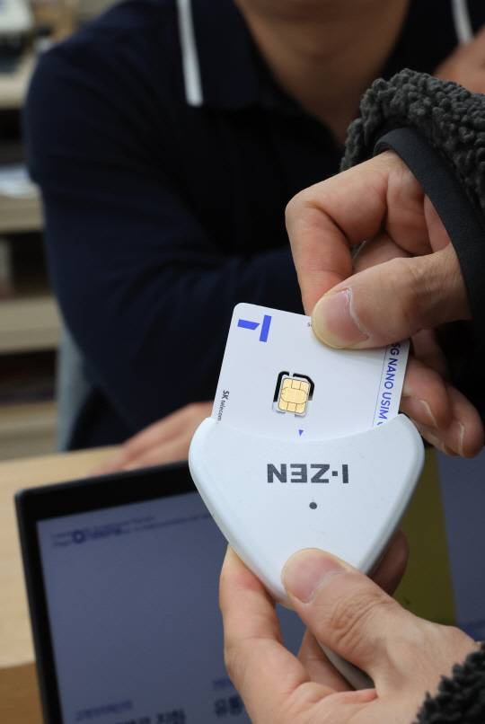 서울 시내 한 SK텔레콤 대리점에서 직원들이 유심 재설정을 시연하고 있다. 연합뉴스