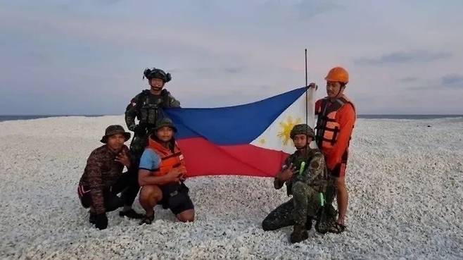 필리핀 경찰이 남중국해 모래톱에서 똑같은 자세로 국기를 들고 사진을 찍은 모습. 필리핀 정부