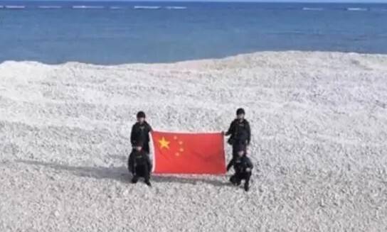 중국 해경대원들이 오성홍기를 들고 남중국해의 샌디케이 암초(중국명 톄셴자오) 위에서 사진을 찍고 있다. 중국 중국중앙텔레비전(CCTV)