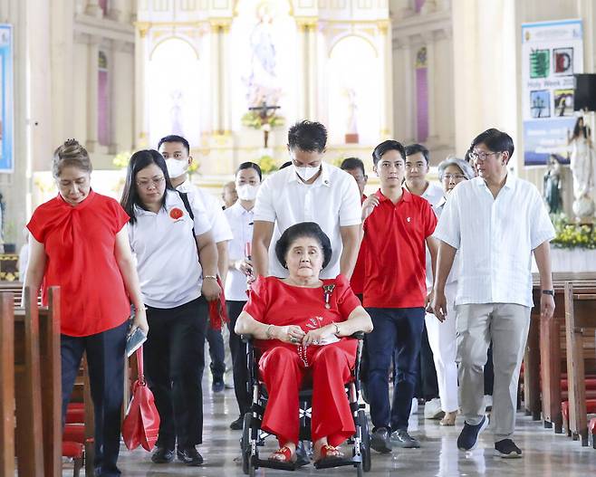 페르디난드 마르코스 주니어 필리핀 대통령(오른쪽)과 그의 어머니 이멜다 마르코스(가운데)가 12일 실시된 필리핀 총선에서 투표하기 전 북일로코스의 교회를 방문했다. 북일로코스/AP 연합뉴스