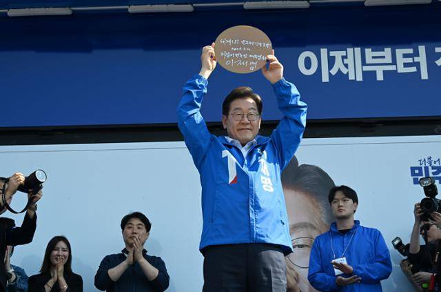 이재명 더불어민주당 대선후보가 12일 경기 화성시 동탄센트럴파크에서 열린 집중유세에서 자신의 서명이 담긴 반도체 웨이퍼를 들어 보이고 있다. 고영권 기자