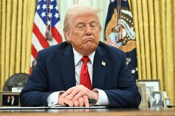 도널드 트럼프 미국 대통령이 지난 3월 31일(현지시간) 워싱턴 DC 백악관 집무실에서 행정명령에 서명하며 취재진 질문에 답하고 있다. AFP=연합뉴스