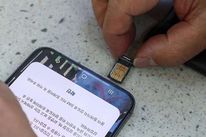 인천 중구 인천국제공항 1터미널 SK텔레콤 로밍센터 앞에서 한 여행객이 유심을 교체를 하고 있다. 사진=임형택 한국경제신문 기자