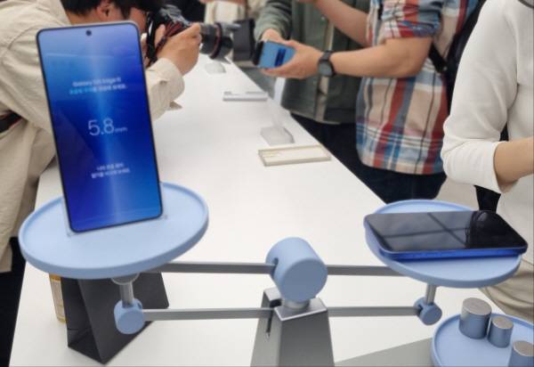 갤럭시 S25 엣지와 170그램 가량의 아이폰 제품을 저울로 잰 모습. 갤럭시 S25 엣지 무게는 163그램이다. 정옥재 기자