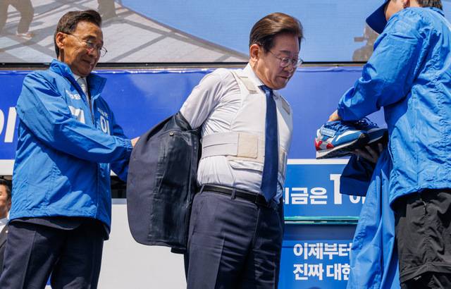 더불어민주당 이재명 대선후보가 12일 오전 서울 광화문 청계광장 첫 유세에서 선거운동복을 전달 받기 위해 자켓을 벗자 방탄복이 드러나 보이고 있다. 이병주 기자