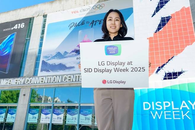 LG디스플레이 직원이 12일(현지시간) 세계 최대 디스플레이 전시회 ‘SID 2025’가 열리는 미국 새너제이 맥에너리컨벤션센터 앞에서 참가 소식을 알리고 있다. <LG디스플레이>