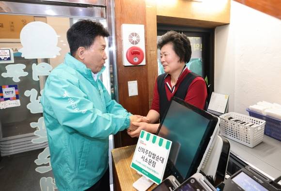 함영주 하나금융지주 회장(왼쪽)이 26일 서울 중구에 위치한 한 소상공인 사업장을 찾아 실내 보수 지원 활동을 펼친 뒤 소상공인과 두 손을 맞잡고 이야기를 나누고 있다. /사진=하나금융지주