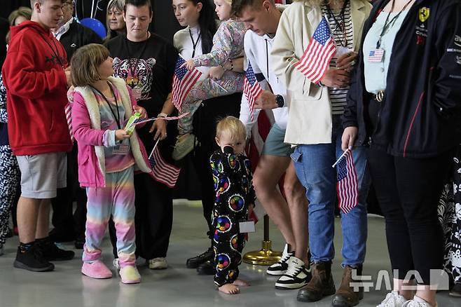 [버지니아=AP/뉴시스]=남아프리카공화국 출신의 아프리카너 난민들이 미국 국기를 들고 2025년 5월 12일 월요일, 버지니아주 덜레스에 위치한 덜레스 국제공항에 도착하고 있다. 2025.05.13.