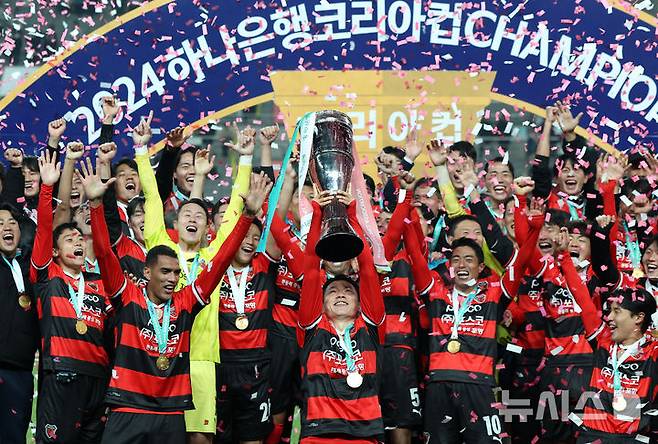 [서울=뉴시스] 홍효식 기자 = 30일 서울 마포구 상암월드컵경기장에서 열린 2024 하나은행 코리아컵 결승전 포항스틸러스와 울산 HD FC의 경기에서 승리한 포항스틸러스 선수들이 트로피를 들어올리며 환호하고 있다. 2024.11.30. yesphoto@newsis.com