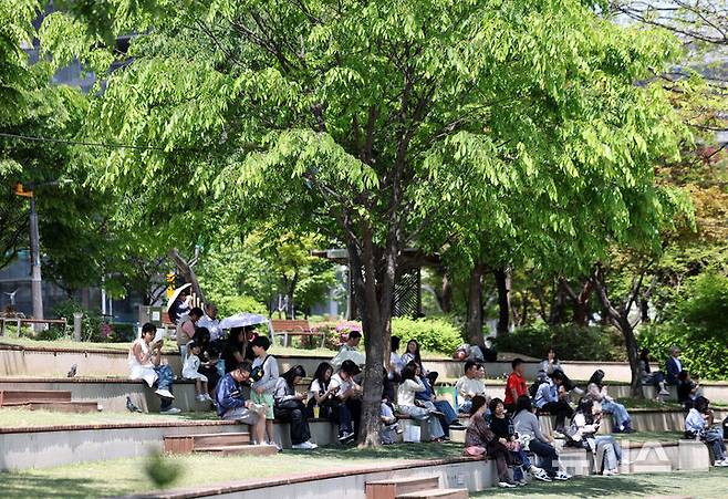 [서울=뉴시스] 김진아 기자 = 서울 낮기온이 26도로 초여름 더위를 보인 30일 서울 송파구 석촌호수에서 시민들이 그늘에서 더위를 피하고 있다. 2025.04.30. bluesoda@newsis.com