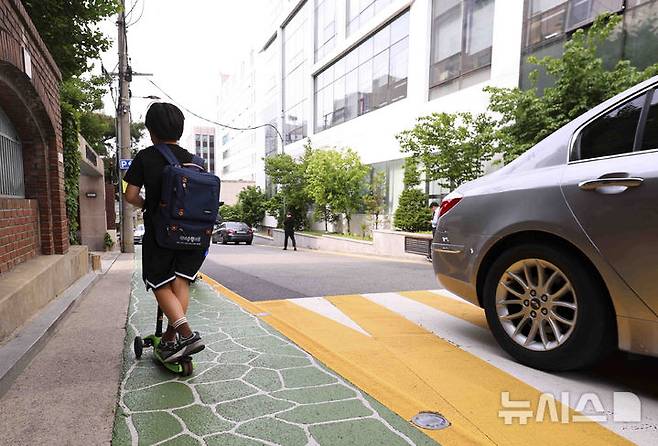 [서울=뉴시스] 김근수 기자 = 홍대 레드로드와 반포 학원가에서 오는 16일부터 '킥보드 없는 거리' 운영이 예정된 가운데 13일 서울 서초구 반포 학원가에서 한 어린이가 킥보드를 타고 있다. 서울시는 오는 5월 16일부터 홍대 레드로드와 반포 학원가 일대에 '킥보드 없는 거리'를 운영해, 낮 12시부터 밤 11시까지 전동킥보드 등 개인형 이동장치(PM)의 통행을 금지한다고 밝혔다.금지 대상은 전동킥보드, 전동이륜평행차, 동력 자전거 등이며, 위반 시 일반도로는 범칙금 3만원·벌점 15점, 어린이보호구역은 6만원·벌점 30점이 부과된다. 2025.05.13. ks@newsis.com