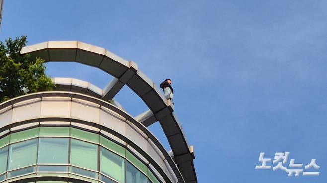 13일 서울 강남구 강남역 인근 빌딩에서 한 남성이 투신을 시도하는 소동이 일어났다. 남성이 옥상 난간에 서 있는 모습. 송선교 기자