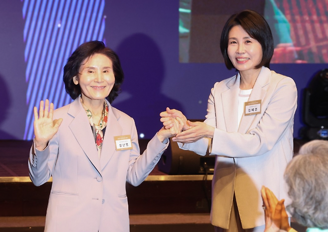 국민의힘 김문수 대선 후보의 부인 설난영 씨와 더불어민주당 이재명 대선 후보의 부인 김혜경 씨가 12일 서울 중구 신라호텔에서 열린 중앙신도회 창립 70주년 기념식에서 손을 맞잡고 있다. 연합뉴스