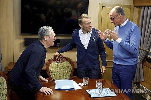 키이우 가는 프랑스·독일·영국 정상 9일(현지시간) 우크라이나로 향하는 기차 안에서 대화하는 영국 스타머(왼), 독일 메르츠(우) 총리와 프랑스 마크롱 대통령(가운데). 마크롱 대통령의 물잔 옆에 흰색 휴지가 놓여있다. [AP 연합뉴스 자료사진. 재판매 및 DB 금지]