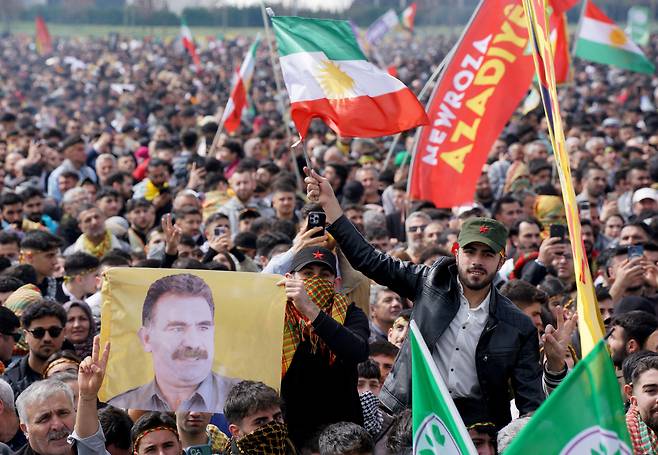지난 3월 23일 튀르키예 이스탄불에서 열린 뉴로즈 봄 축제에서 참가자들이 26년째 수감 중인 쿠르드 노동자당(PKK) 지도자 압둘라 외잘란의 모습이 담긴 깃발을 들고 있다. /로이터 연합뉴스