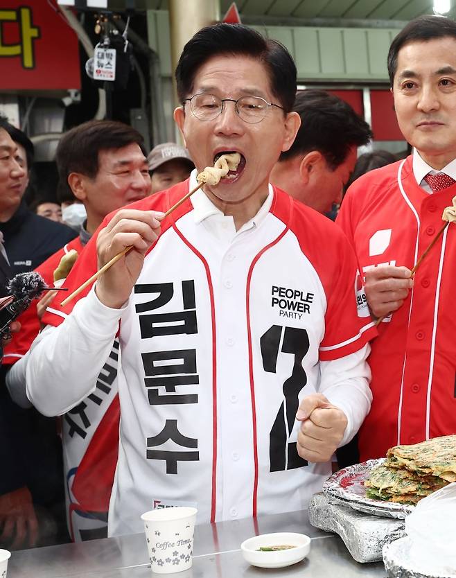 국민의힘 김문수 후보가 14일 경남 진주시 진주중앙시장을 방문해 어묵을 먹고 있다. 연합뉴스