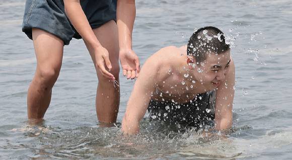 초여름의 날씨로 낮 최고기온이 20∼29도를 보인 지난 13일 서울 영등포구 여의도물빛광장에서 현장체험학습을 마친 중학생들이 물놀이를 하며 더위를 식히고 있다. [사진=연합뉴스]