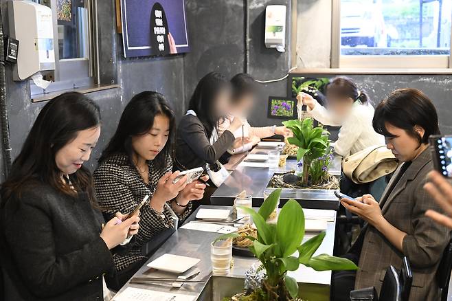Participants take a photo before tasting dishes prepared by North Korean defector chefs at a restaurant in Mapo District, western Seoul, on May 9. [MINISTRY OF UNIFICATION]