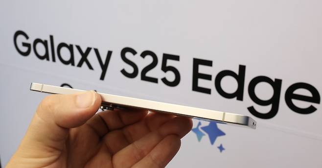 Samsung Electronics’ Galaxy S25 Edge is held sideways to highlight its thin design at the company’s Gangnam branch in southern Seoul on May 13. It is the thinnest smartphone in the entire Galaxy lineup. [NEWS1]
