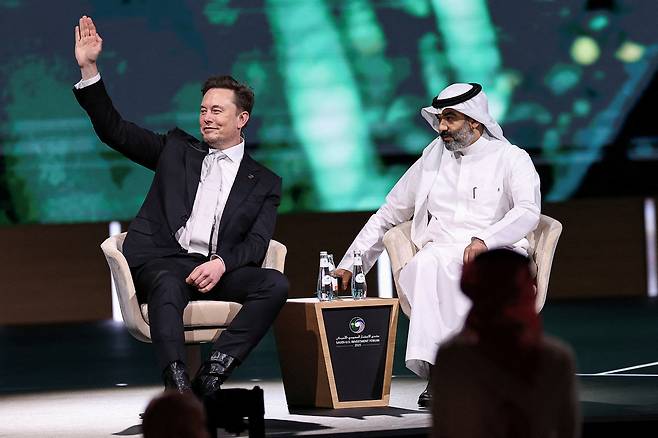 Tesla CEO Elon Musk, left, sits with Saudi Minister of Communications and Information Technology Abdullah Alswaha at the Saudi-U.S. Investment Forum, in Riyadh, Saudi Arabia, on May 13. [REUTERS/YONHAP]