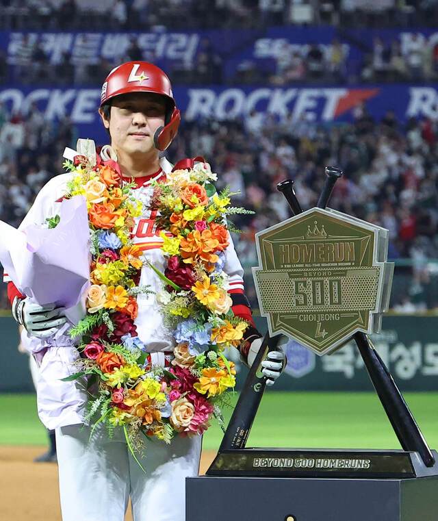 리그 사상 최초로 500홈런을 달성한 최정이 꽃다발을 들고 기념 조형물과 함께 포즈를 취하는 모습. 연합뉴스